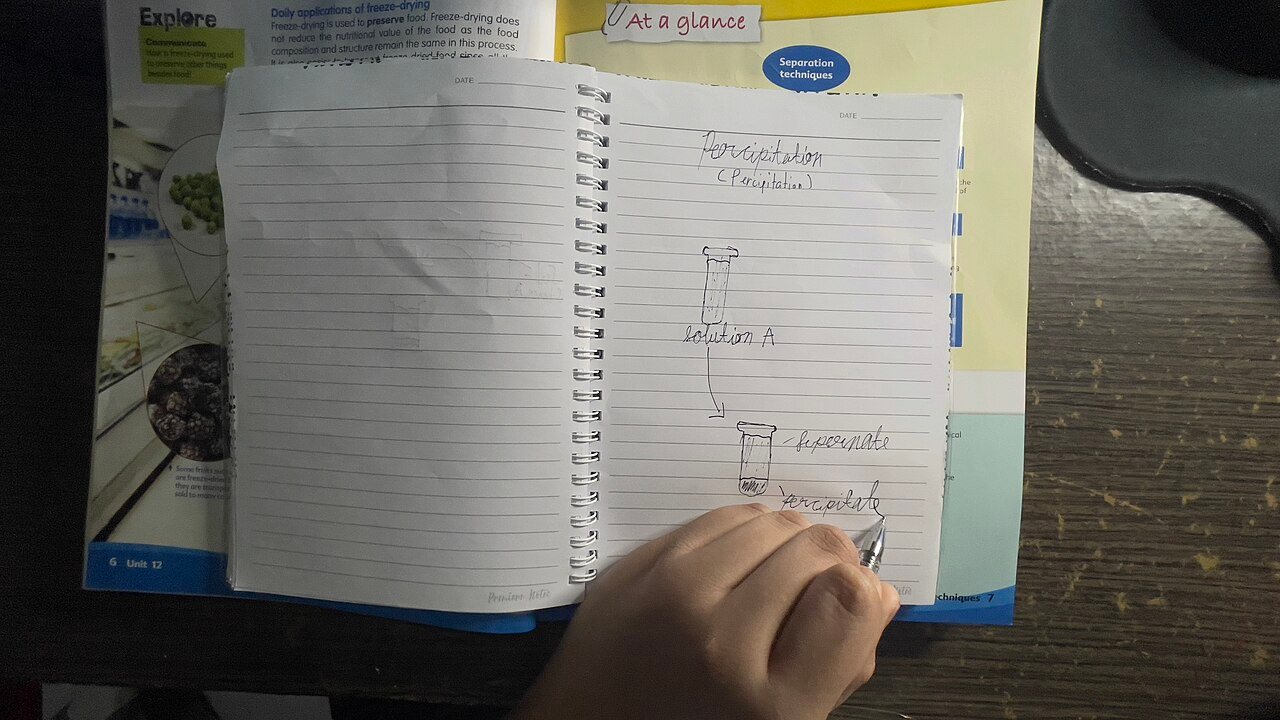屋内の机でノートに図を手書きしている一人の手元の写真