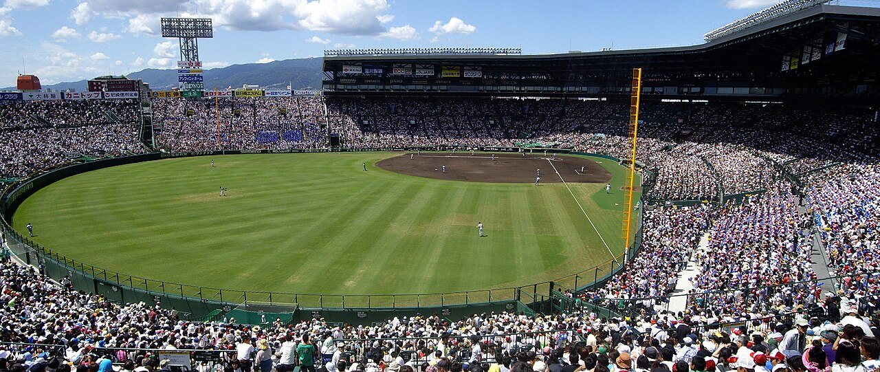 晴天の甲子園球場を外野スタンドから撮った満員の試合風景