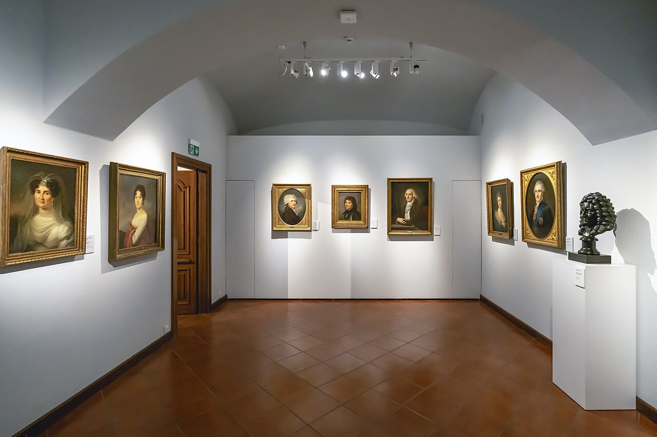 屋内、無人の美術館展示室に肖像画や胸像が並ぶ様子