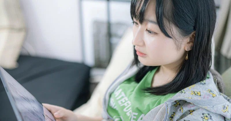 室内のソファで一人の女性がタブレット端末を見ている様子