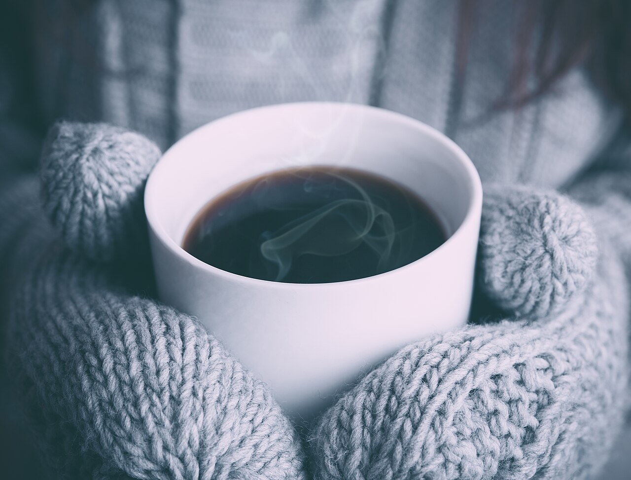 温かいコーヒーを持つ手元の写真