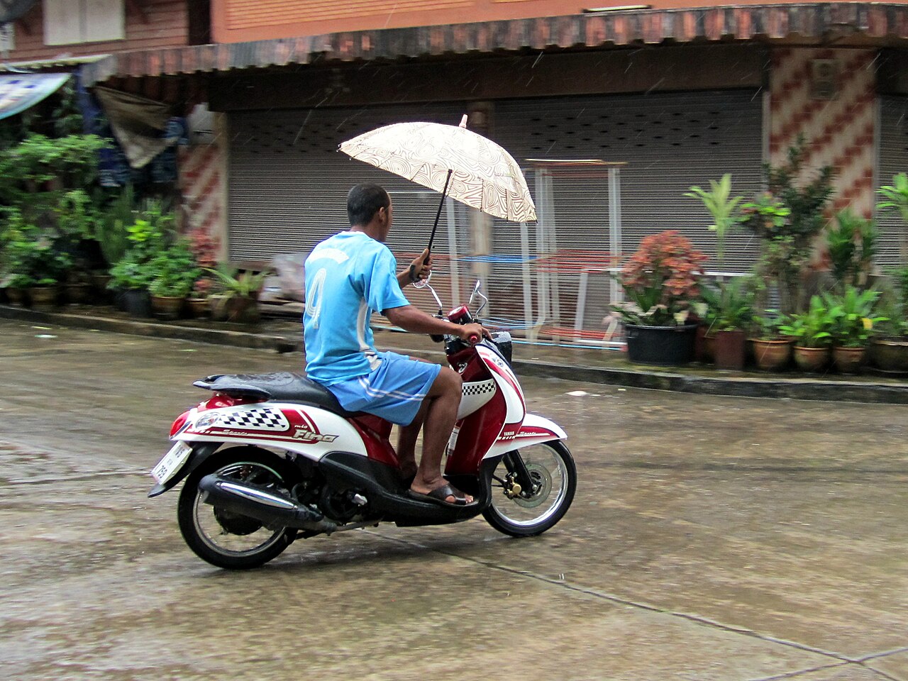 雨の中、傘をさす人物のスナップ写真