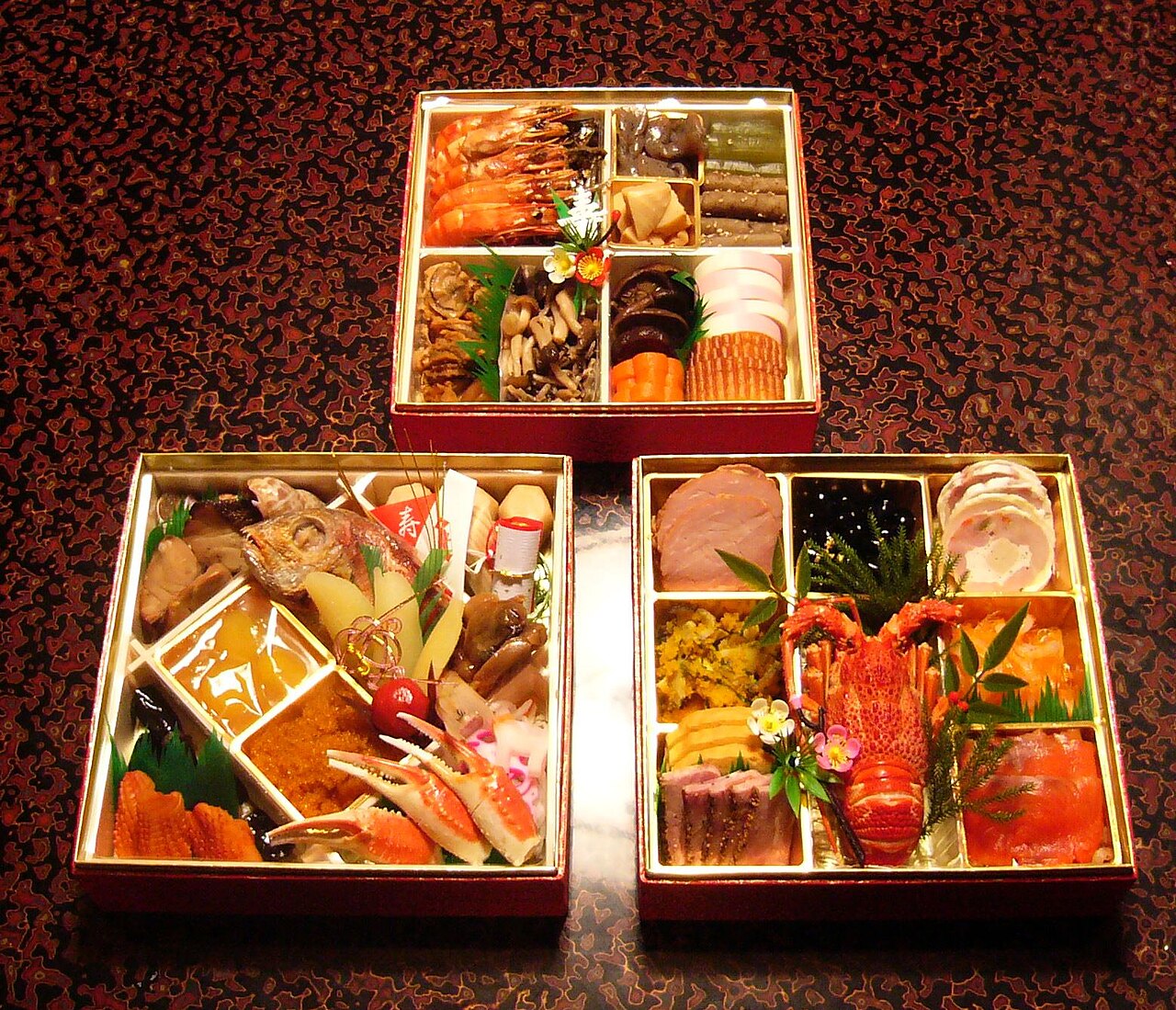 黒塗りの重箱3段に海老やかまぼこなど和食を詰めたおせち料理