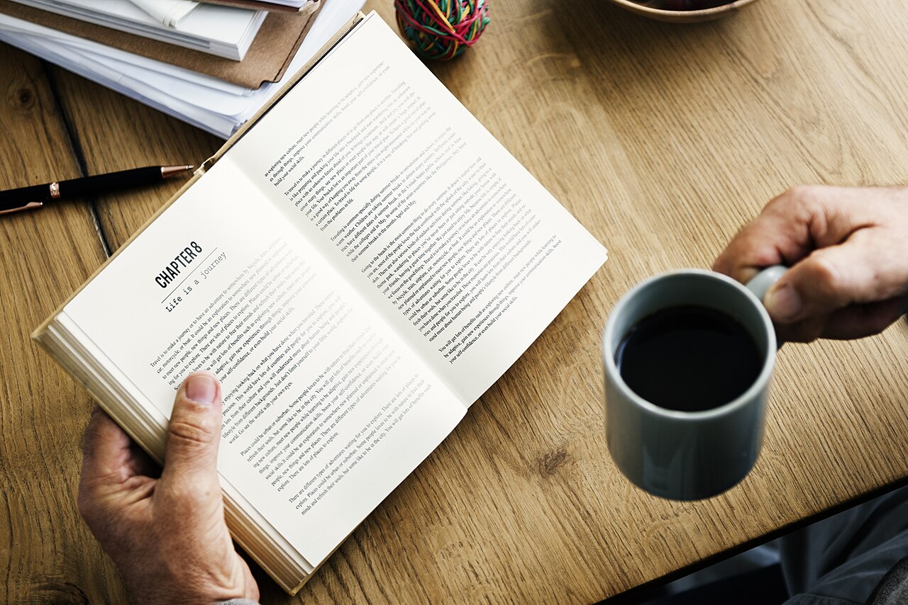 カフェで本を読む男性
