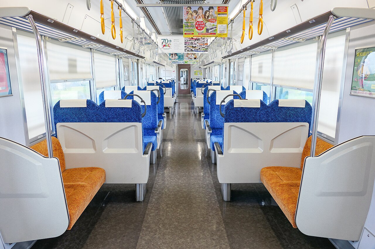 無人の新幹線車両内、青とオレンジの座席が並ぶ通路