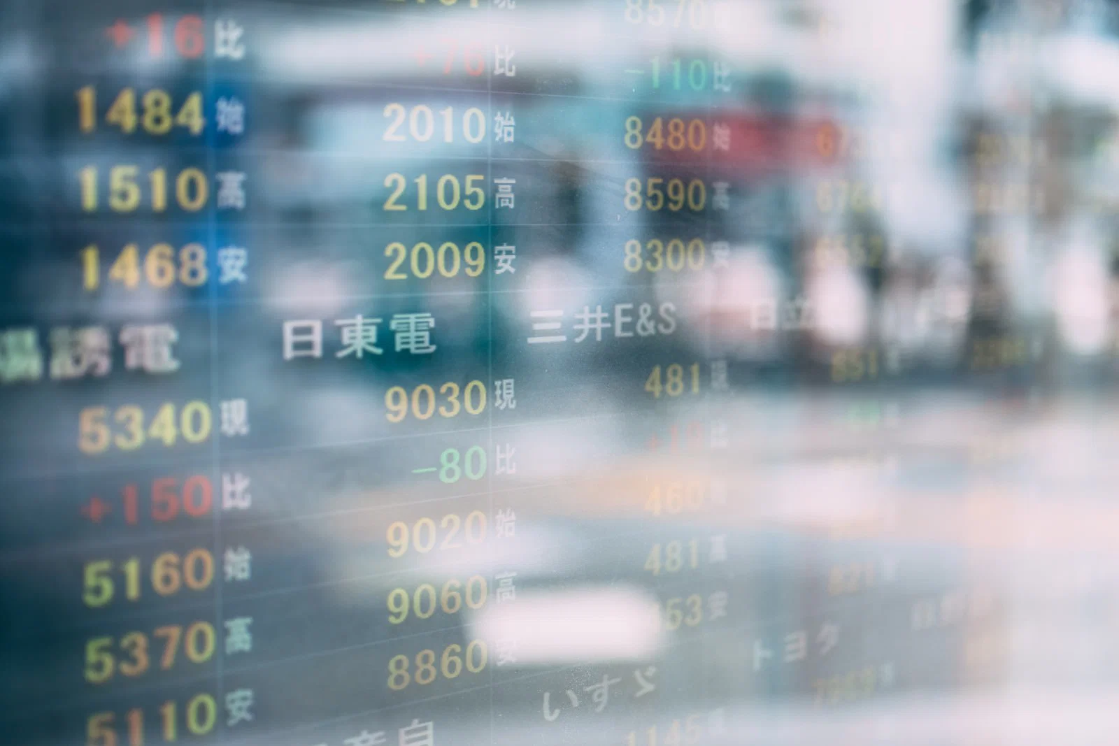 日本語の株価銘柄と数値が並ぶ電光掲示板のクローズアップ写真