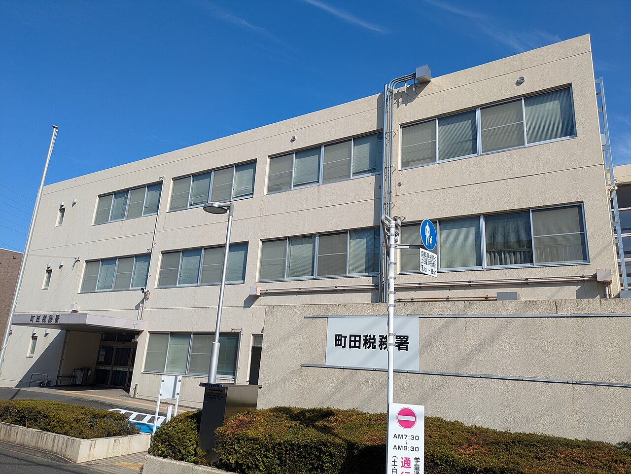 「町田税務署」と表示された3階建ての税務署庁舎を斜めから撮った写真