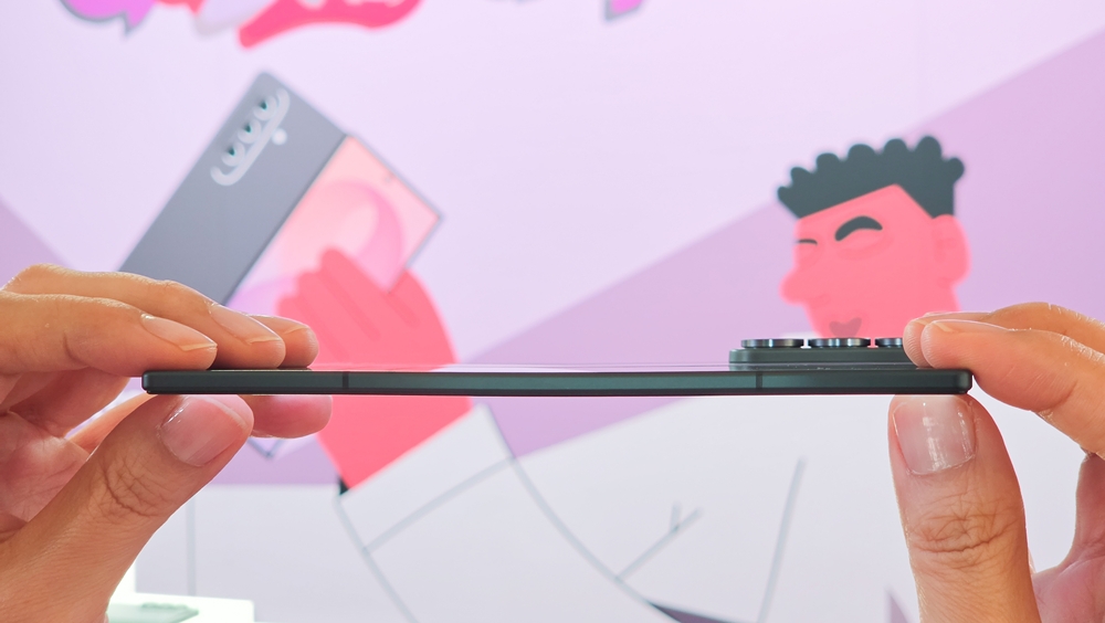 両手でスマートフォンの側面上端を持ち、その薄さを強調したクローズアップ写真
