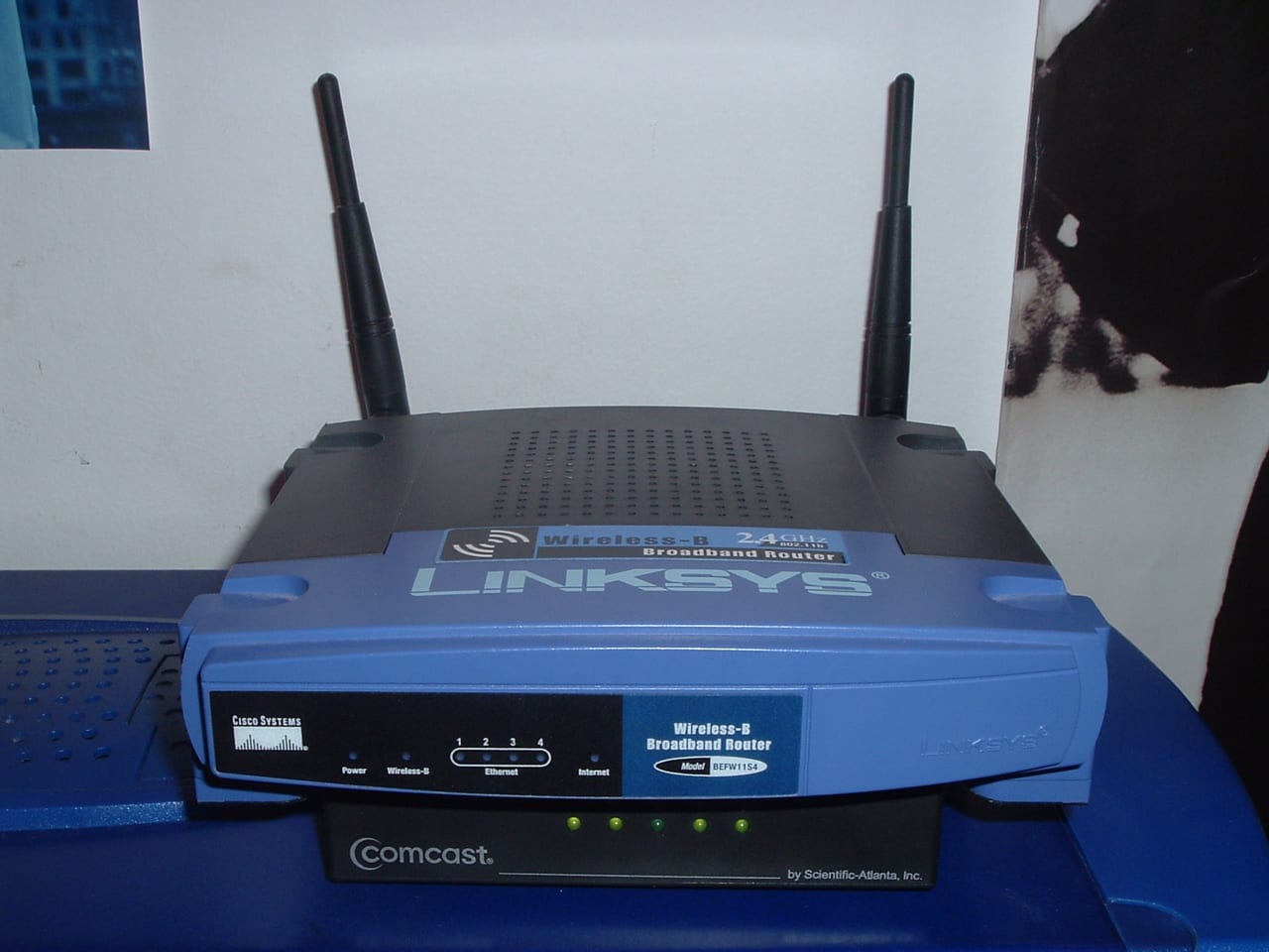 アンテナ2本のLinksys無線ルーターがコムキャスト機器の上に置かれている