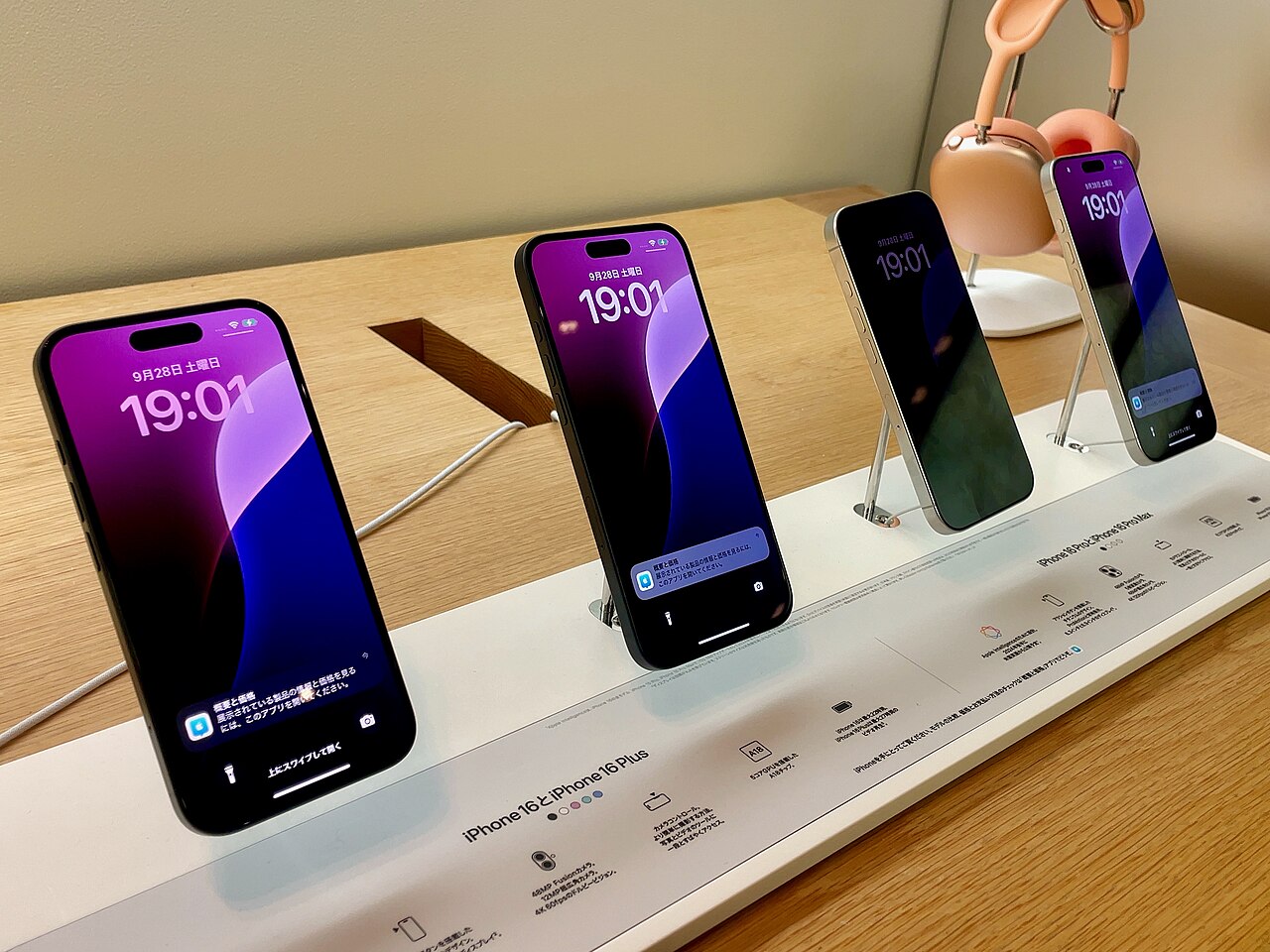 屋内の店舗什器に4台のiPhoneが並べて展示されている様子