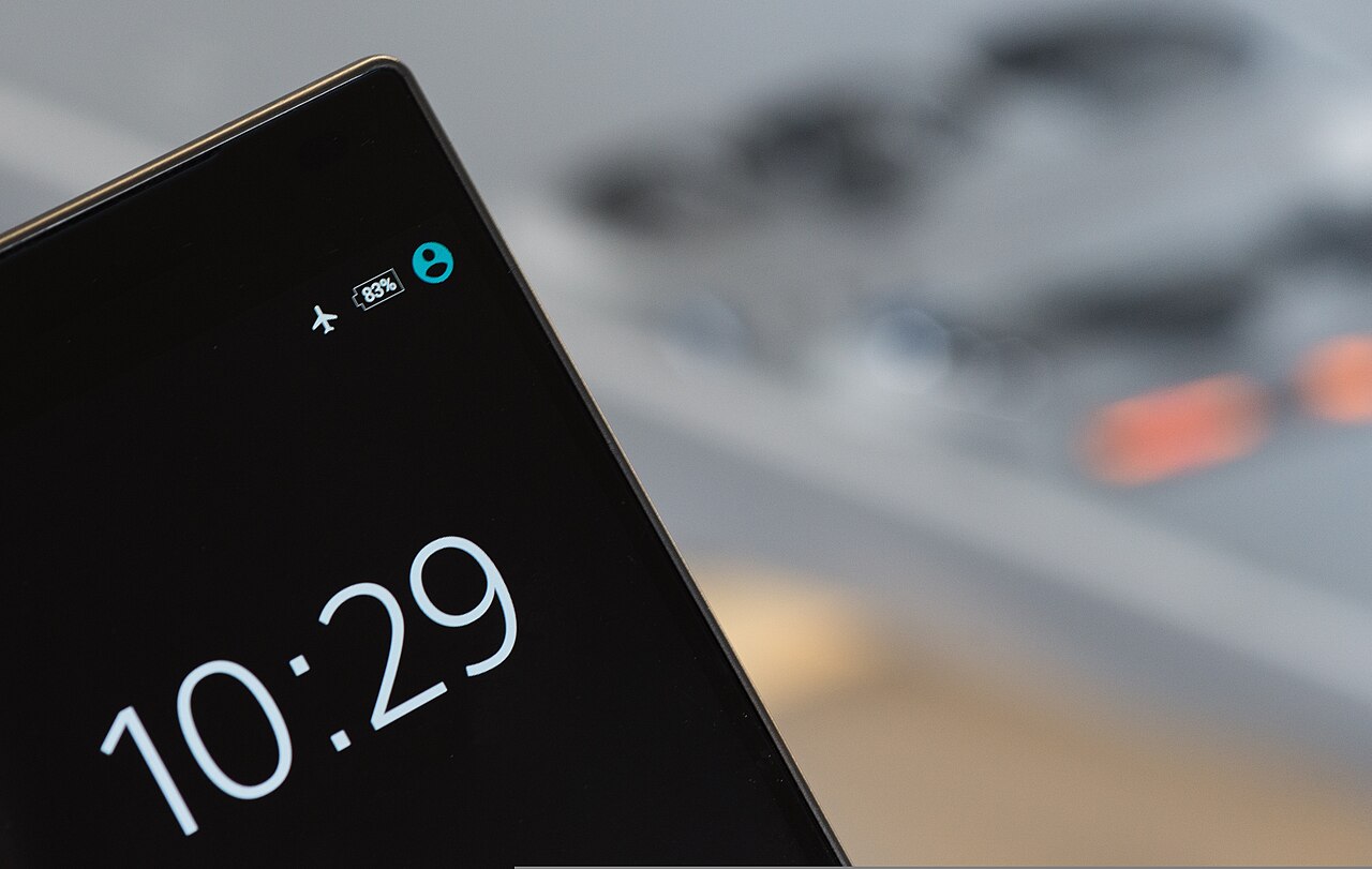 画面に時刻と電池残量が表示されたスマートフォンのクローズアップ