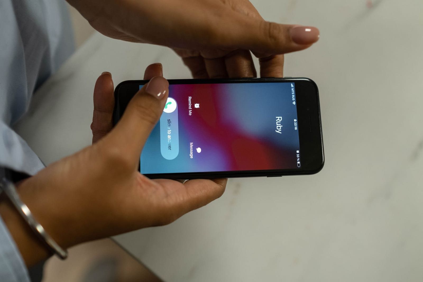 着信中のスマートフォンを両手で持つ様子