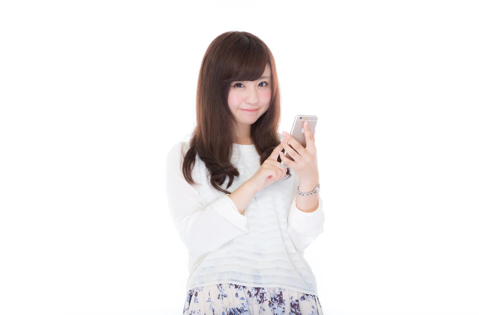白背景でスマートフォンを操作する日本人女性1人の上半身写真